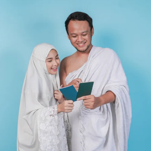 Young Asian Muslim couple in ihram and prayer gown looking at each other passport. Hajj concept. Young Asian Muslim couple in ihram and prayer gown looking at each other passport. Hajj concept.
